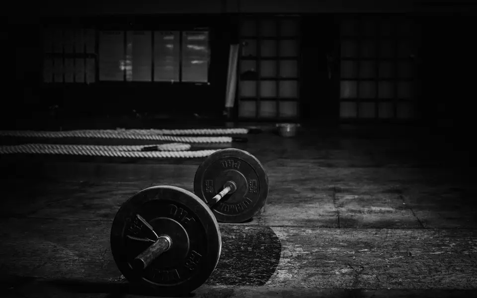 Loaded barbell on an empty gym floor before open