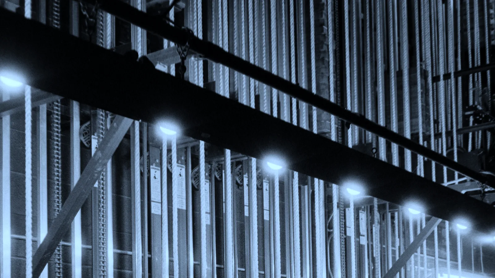 A theatre lighting rig seen from the wings, tinted blue