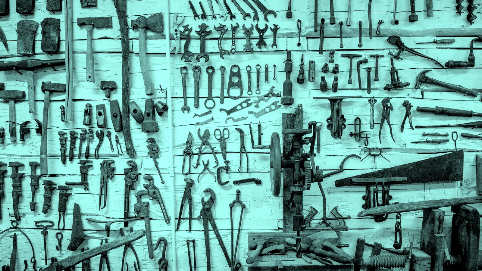 A wall of well-worn hand tools, tinted teal