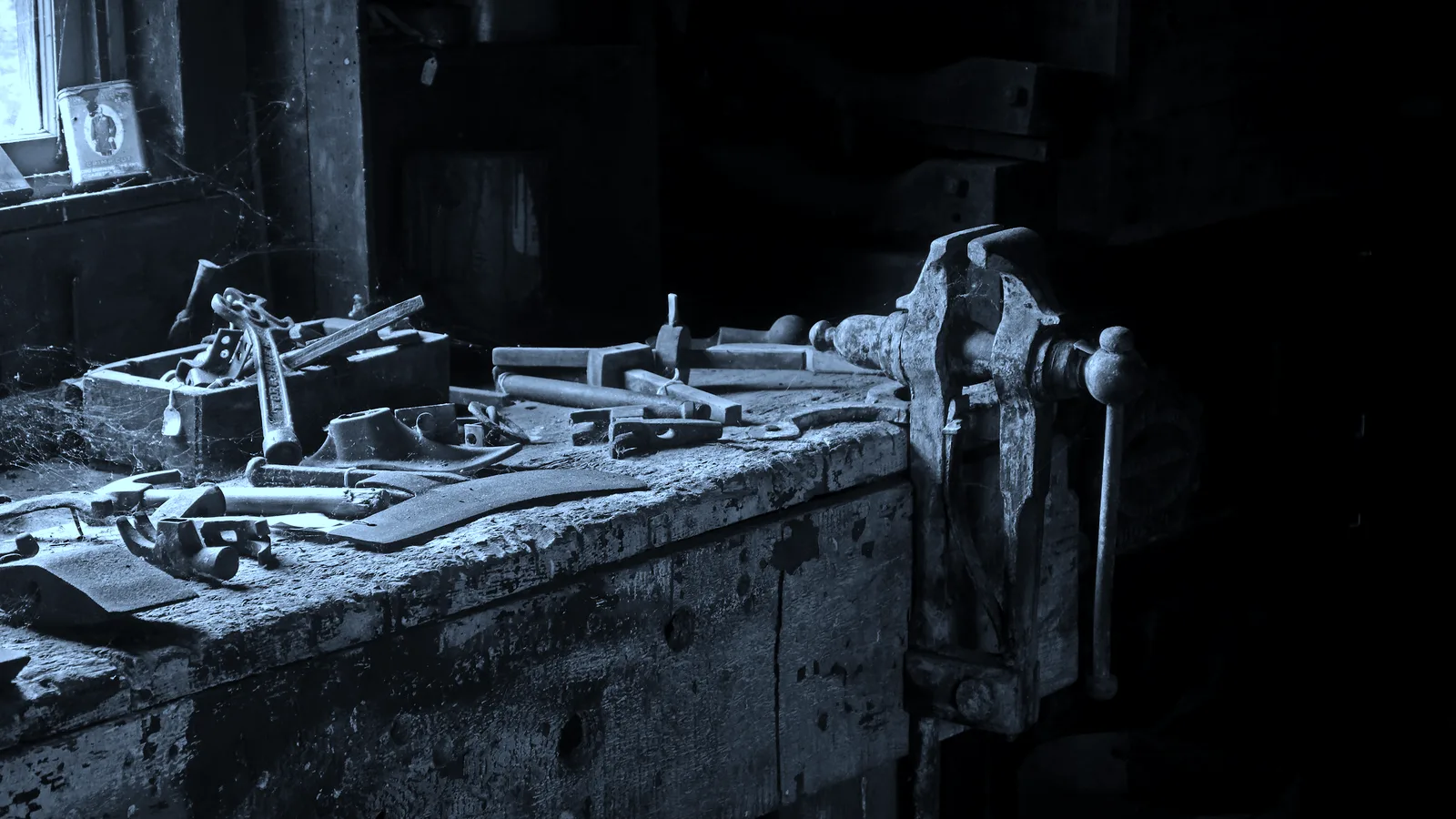 A workbench covered in tools with the job half done, tinted blue